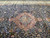 Center medallion viewed from the side with ivory floral field and top ivory border beyond
