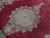 Close-up of seafoam green floral medallion crowded with roses against the raspberry red wool pile