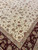 Ivory floral field meeting the deep red border of this large Tabriz design Oriental rug
