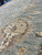 Floor-level view of the pile depth, hand-spun wool sheen and a large cream palmette motif