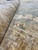 Pile and fold detail revealing dense hand-knotted wool, soft luster and a terracotta outlined flower head
