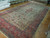 Angled view showing palace size 10x17 Kerman rug, red border and ivory field, full length