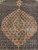 Symmetrical copper medallion with ivory core and green outlines centered on the black Mahi field