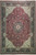 Overhead view of burgundy Kashan design rug with navy border and ivory floral corner spandrels