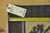 Back of the hand-knotted rug with cotton foundation, navy selvage and tag reading 11.7 x 17.8