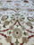 Wool pile detail showing ivory 8 petal rosette, olive leaves and crimson stem tracery