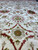 Floral field photographed low showing red sunburst rosette and sage green medallion accents