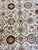 Overhead field detail with pink, olive and burgundy palmettes across an ivory vine lattice