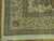 Corner detail showing rust and green floral border, blue guard stripes and cotton fringe
