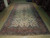9'7" x 19' Persian Kerman rug laid out full length across the warehouse floor