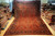 Oversize red Sarouk rug displayed upright showing all over floral field and navy blue border