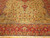 Close view of banana gold field with scrolling floral vines and wide coral red main border