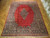 12x15 Persian Sarouk rug laid on parquet floor showing lustrous red open field and medallion