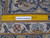 Ruler laid across the pile for scale, with knot structure and border flowers visible