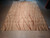 Whole rug laid flat on a concrete warehouse floor, red lines leaning across the beige ground