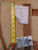 Tape measure and lot tag resting on the pile, showing knot structure and woven selvedge