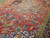 Serrated leaf and palmette motifs filling the red field around the geometric medallion center