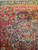 Coral star medallion with gold arabesques and navy pendant, seen from the rug end