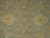 Close-up of the field showing cream palmettes and gold vine work on grey-blue wool