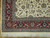Corner detail with red main border, grey-green guard stripes and the long cream fringe below
