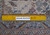 Back of the rug beside a ruler, confirming authentic hand-knotted wool construction and tight weave