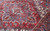 Hand-knotted wool pile detail showing sky blue, rose and brown tones across medallion and border