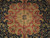 Close-up of gold central medallion with red palmettes, sage leaves and dense navy floral field