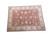 Angled studio shot of 12x16 hand-knotted wool Ziegler rug in coral and ivory tones