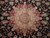 Close view of the round central medallion in burgundy and ivory against dense black floral ground