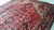 Wool pile shown at floor level, rust red Heriz rug with ivory corner spandrels