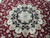 Detail of black medallion with ivory palmettes, pink rosettes and sage leaves on red ground