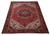 10'3 x 13'10 hand-knotted Heriz rug photographed at an angle showing brick field and dark border