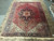 10' x 13'5" Persian Heriz rug laid flat on tile floor with ivory fringe both ends