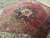 Angled view of vintage 1970s Heriz rug showing indigo medallion, salmon florals and soft wool pile
