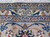 Woven signature cartouche set into the ivory guard border of this signed Persian Kashan rug