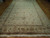 Full length view of oversize wool and silk area rug with cream field and vine scroll