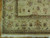 Corner detail showing olive guard stripes, gold palmettes and ivory cotton fringe of the rug
