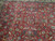 Close-up of red field showing paired birds, running gazelles, lotus palmettes and dark navy leaf sprays
