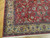 Corner detail with gold ground border, navy guard stripes, green leaves and ivory fringe on wood