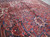 10x13 Persian Heriz rug photographed at floor level, showing dense wool pile and olive accents