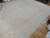 12 x 15 Pakistani Chobi Peshawar rug photographed at an angle across a hardwood living room floor