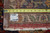 Back of the rug with tape measure and inventory tag, showing cotton foundation and knotting