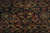 Border detail showing camel gold palmettes, rust rosettes and vine scroll on indigo blue ground