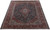Deep navy Kashan rug photographed at an angle, showing red vine border and all-over floral field