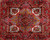 Close-up of the stepped geometric medallion in sky blue, gold and ivory on red