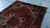 Hand-knotted 7x10 Heriz rug laid on concrete floor showing full even wool pile