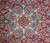 Close-up of the layered star medallion in ivory, sky blue and gold on red wool