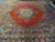 Persian Kerman area rug shown from above, open coral field framed by floral spandrels