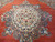 Salmon and cream medallion with scrolling flower sprays spreading across the coral red ground