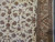 Sage green leaves and rose palmettes scroll across the ivory field beside the triple guard border